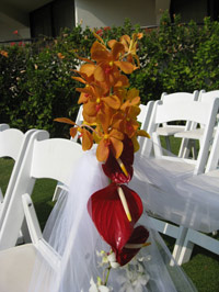 Floral arrangement on wedding aisle chair.