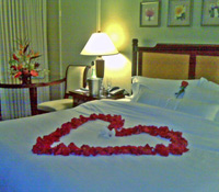 Maui Honeymoon Special showing heart of petals on the bed and floral tropical arrangement.